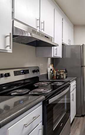 A modern kitchen with stainless steel appliances and white cabinets.