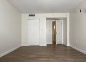 Thumbnail 9 of 14 - an empty living room with white walls and white doors  at Palm Gardens @ Biscayne Gardens, North Miami, Florida