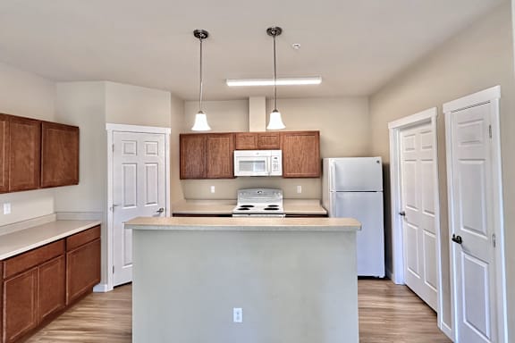 A kitchen with white cabinets and a white fridge.