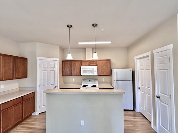 A kitchen with white cabinets and a white island.