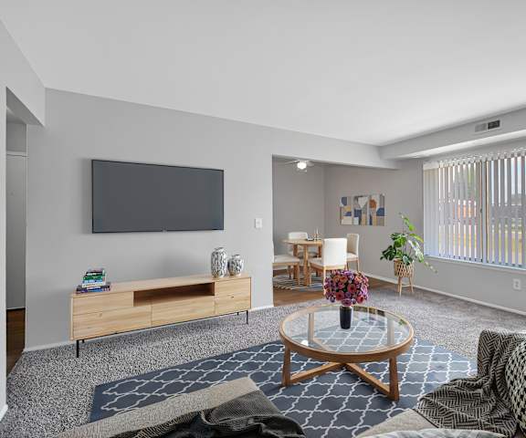 A living room with a flat screen TV mounted on the wall.