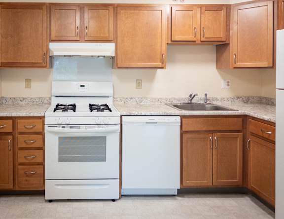 A kitchen with a white oven and a white dishwasher.