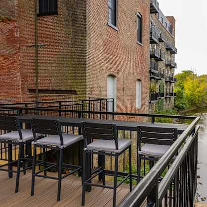 A patio with chairs overlooking a river.