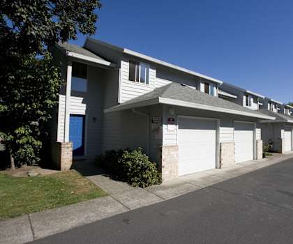 a building with white garage doors and a street in front of it