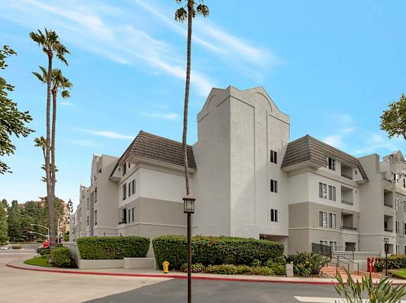 a large white apartment building with palm trees in front of it at Nobel Court, San Diego, CA