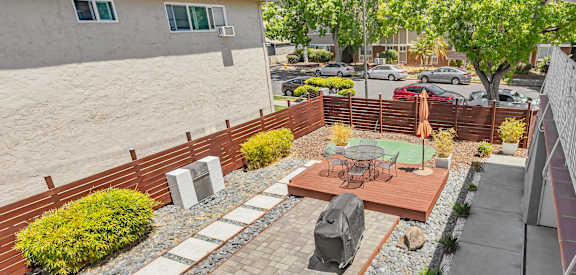 A patio with a table and chairs is surrounded by a brick wall.