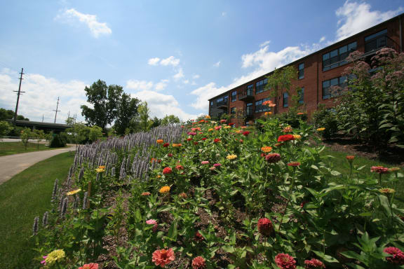 a flower garden in front of a brick building  at Hayden Lofts Apartments, Dublin, Ohio 43016