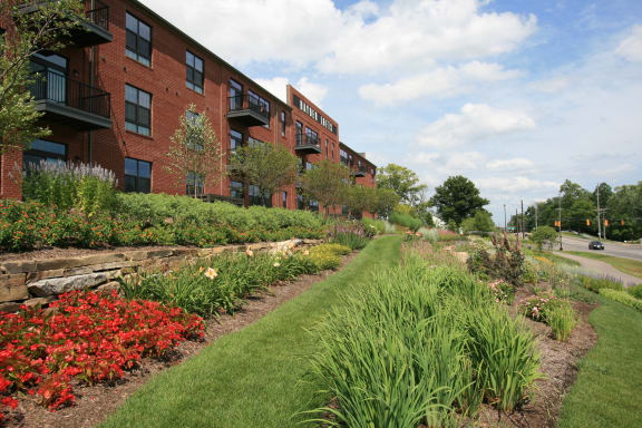 a garden with flowers and trees in front of a building  at Hayden Lofts Apartments, Dublin, 43016
