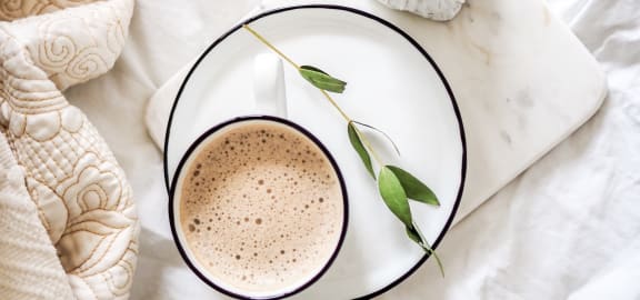 a cup of coffee with a flower on a plate