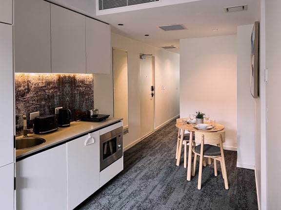 a kitchen and a dining room with a table and chairs