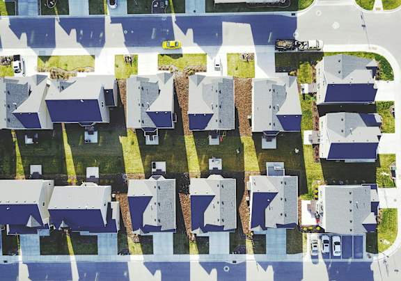 A bird's eye view of a residential area with houses and roads.