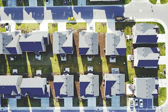A bird's eye view of a residential area with houses and roads.