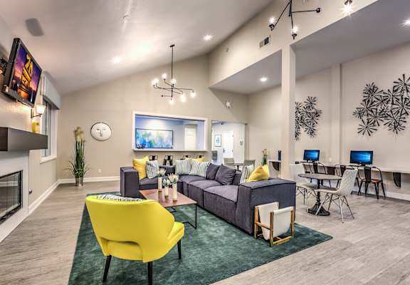 A modern living room with a yellow chair and a grey couch.