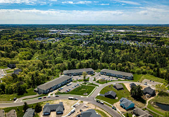 A bird's eye view of a residential area with houses and a large building surrounded by trees.