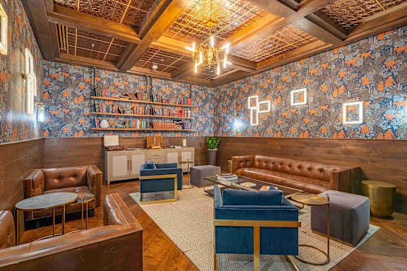 A room with a wooden floor and a blue carpet.