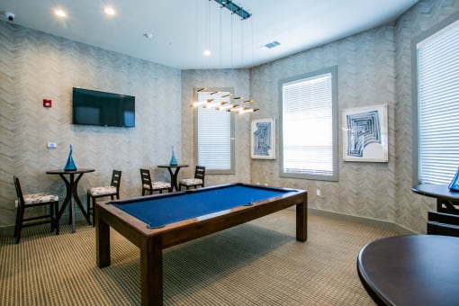 a game room with a pool table and a flat screen tv