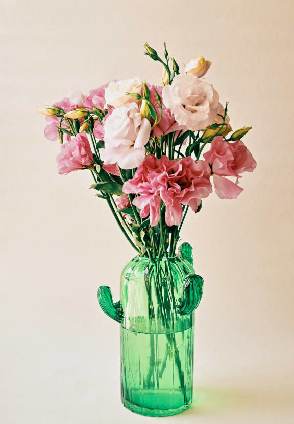 a green vase filled with pink flowers at Oaks of Westlakes Apartments, San Antonio, TX