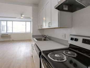 A kitchen with a stove top oven and a window.