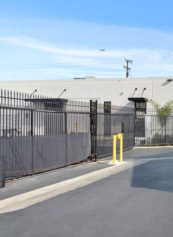Storage units surrounded by a black fence. 
