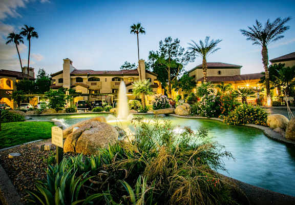 a resort with a pool and a fountain at night