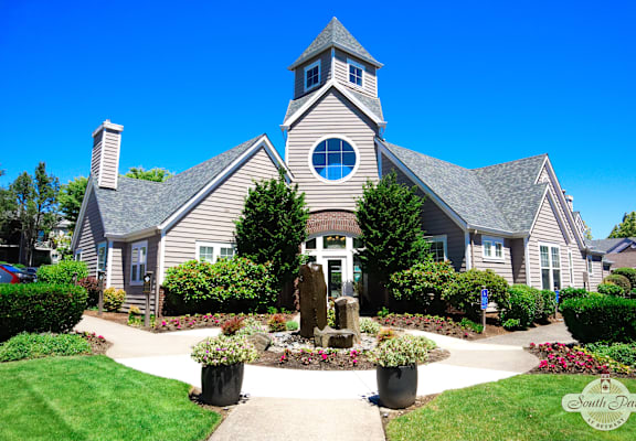 the front yard of a house with a garden and a church