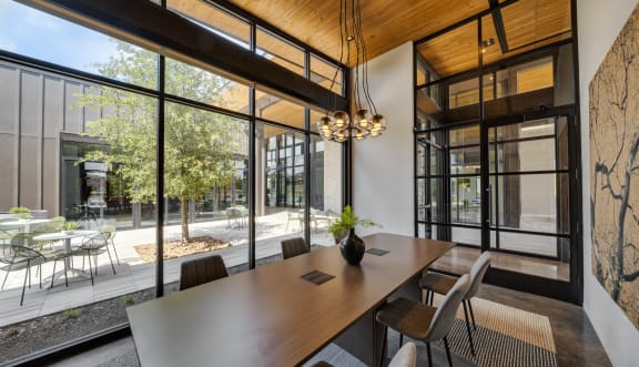 a dining room with large windows and a table and chairs
