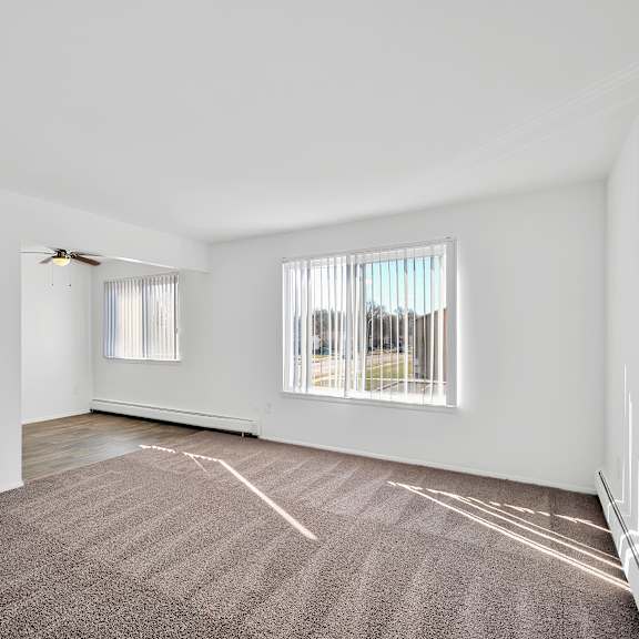 Carpeted apartment living room at Huntington Club Apartments in Warren, MI