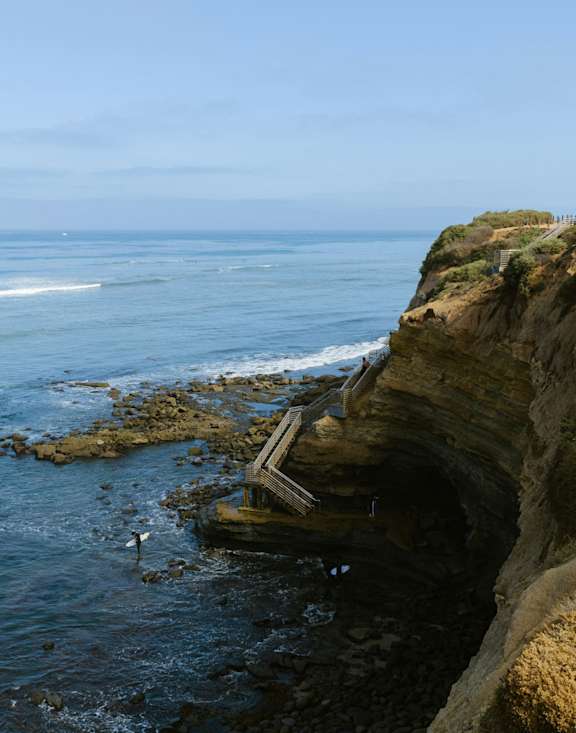 A seagull is standing on a rocky outcrop by the ocean. at Legacy Hills at Poway 55+ Apartments, Poway, California