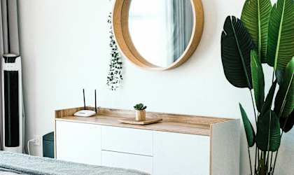 a bedroom with a mirror and a bed and a plant