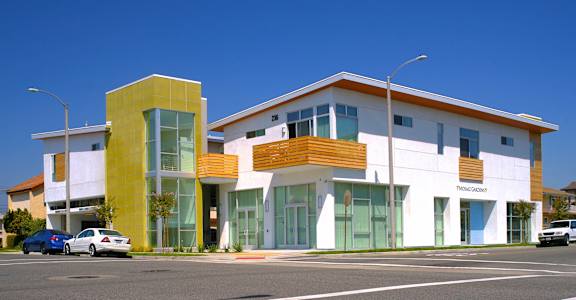 a modern building on the corner of a street with cars