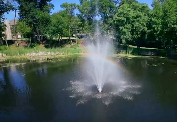 a fountain in the middle of a pond  at Regency Woods, Minnetonka, 55305