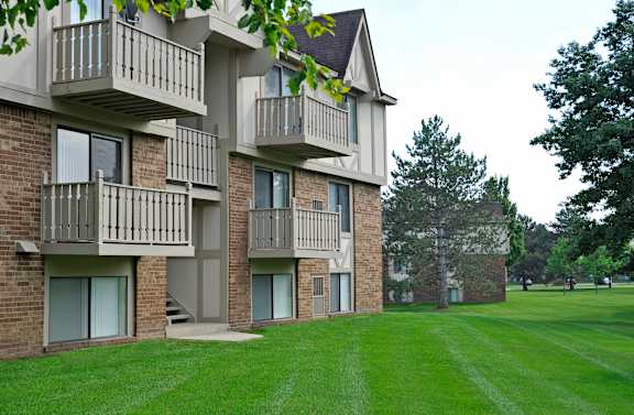 an apartment building with balconies and a green lawn