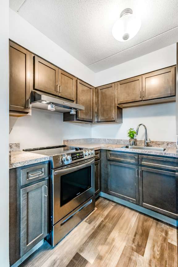 A kitchen with dark wood cabinets and black appliances.