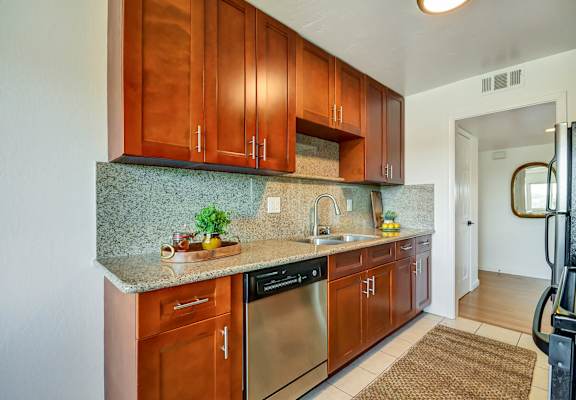 A kitchen with wooden cabinets and a granite countertop.