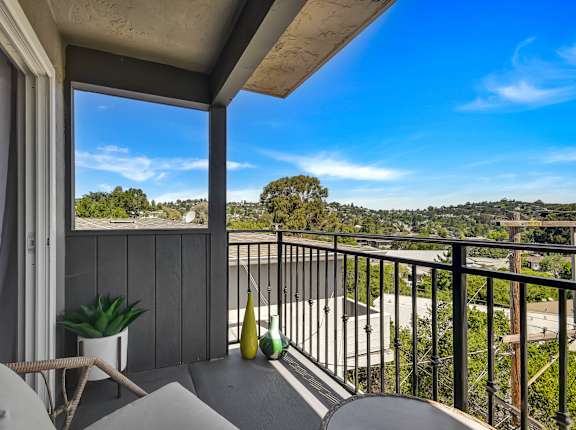 A balcony with a view of the street and houses.