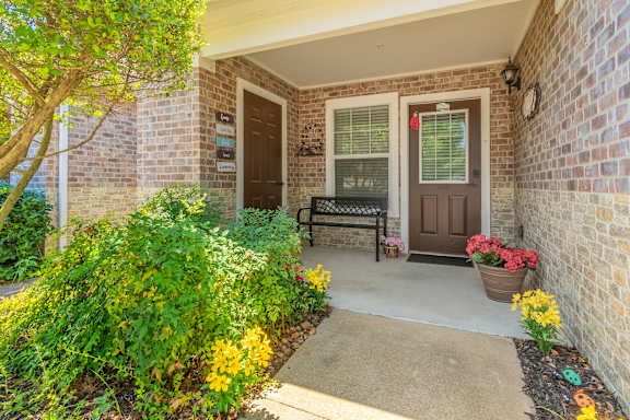 A front porch with a bench and a door.