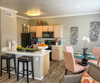A kitchen with a bar area and a dining table with chairs.