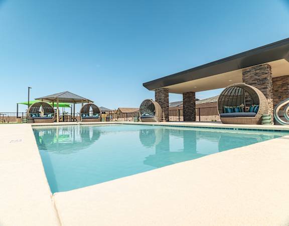 A large swimming pool with a sun lounger and umbrella.