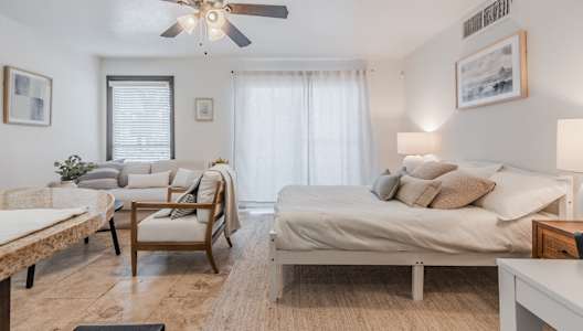 a bedroom with a large bed and a ceiling fan