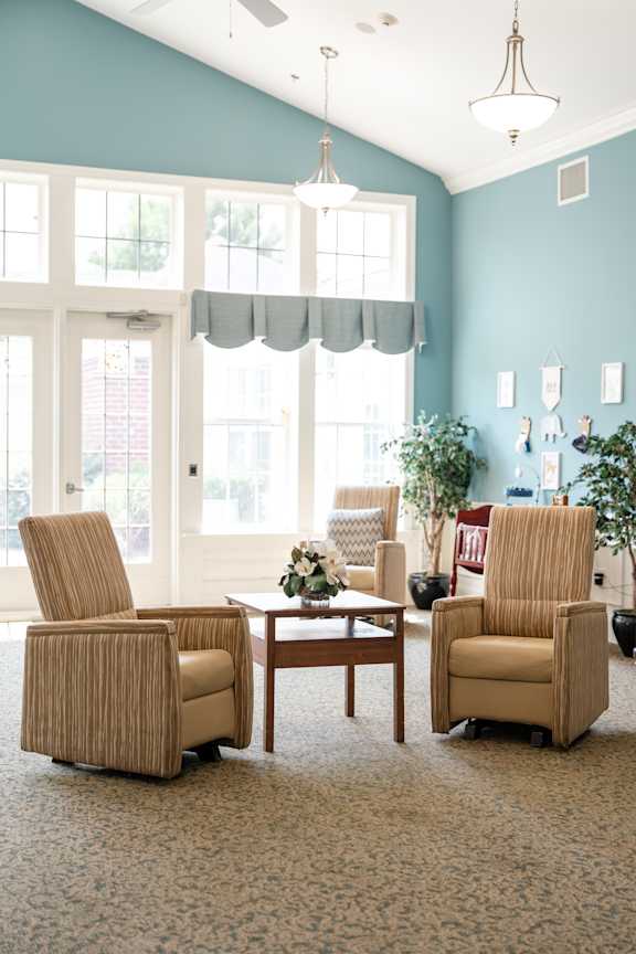 Two chairs and a table are in a room with a window.