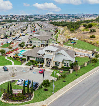 an aerial view of a neighborhood of houses with cars parked on the side of the road