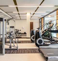 A gym with treadmills, elliptical machines, and other exercise equipment.