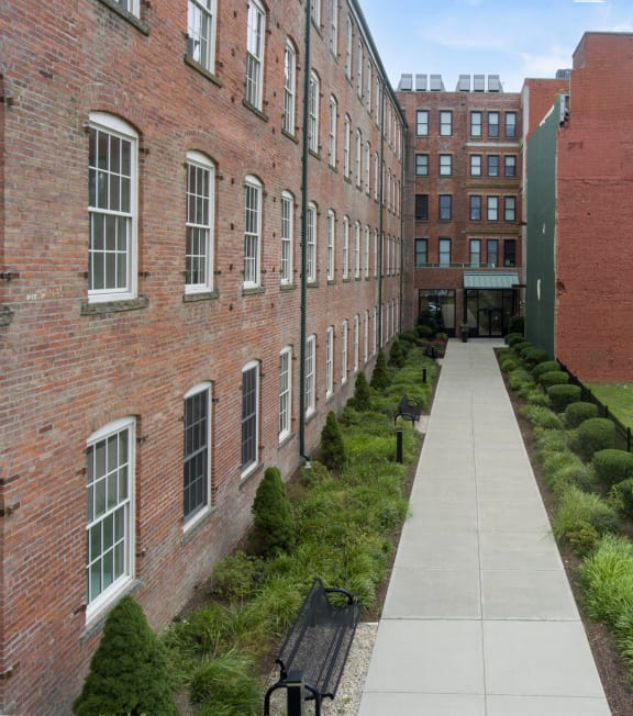 a stone retaining wall with a sign in front of a building at 1188 Lofts in Bridgeport, CT, 06604