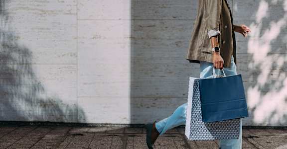 a woman walking with a blue and white bag at Earle Manor Apartments, Wheaton, MD 20902