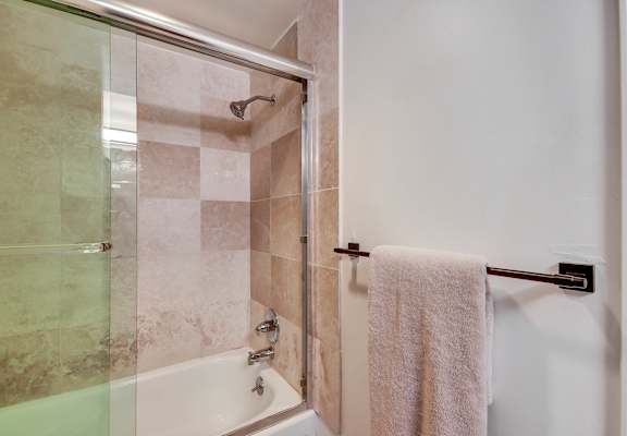 A white towel hangs on a towel bar in a bathroom.