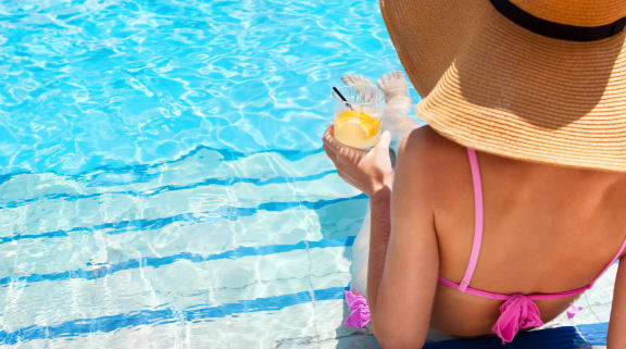 a woman in a hat drinking a cocktail at the pool at 2929 on Mayfair, Wisconsin, 53222