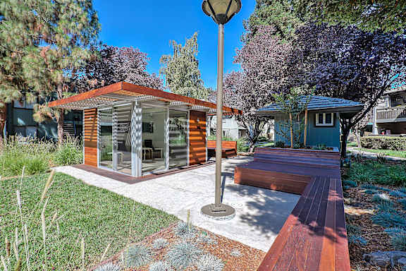 A modern house with a wooden deck and a lamp post.
