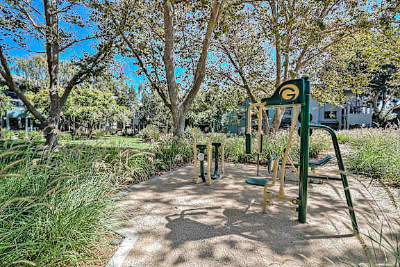 A playground with a green swing set and a yellow slide.