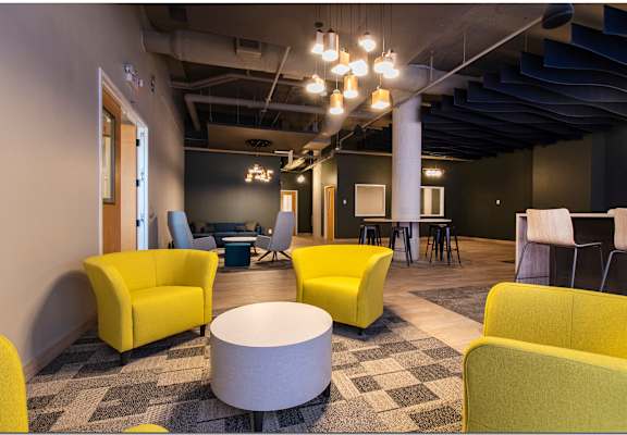 a large room with yellow chairs and grey chairs