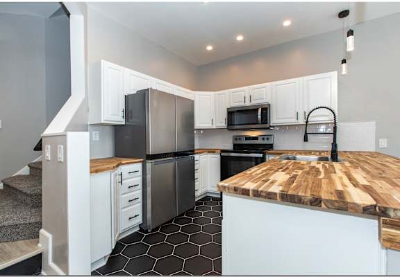 a kitchen with stainless steel appliances and a wooden counter top